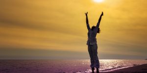 woman celebrating arms to sun How To Know If You're An Empath