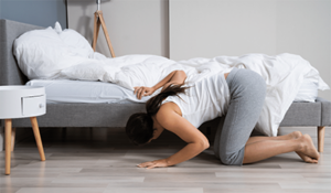 Woman looking under bed lost item