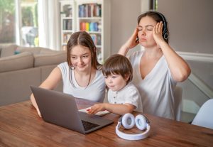 Stressed Mom with 2 kids on her laptop experiencing zoom fatigue