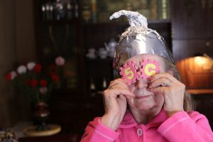 woman with tinfoil hat and 5g stickers over eyes